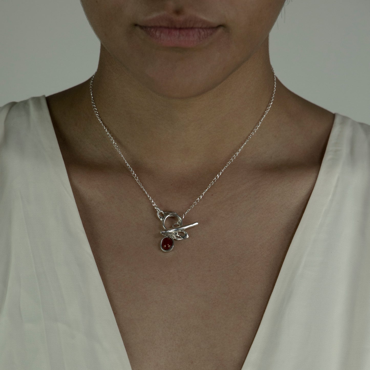The Felicia necklace is a handmade piece made of 925 sterling silver. Its stone is semiprecious and comes in two colors: red carnelian and blue agate. The clasp is located on the front side and is smooth and glossy. In the photograph, the length of the chain is 40 cm.