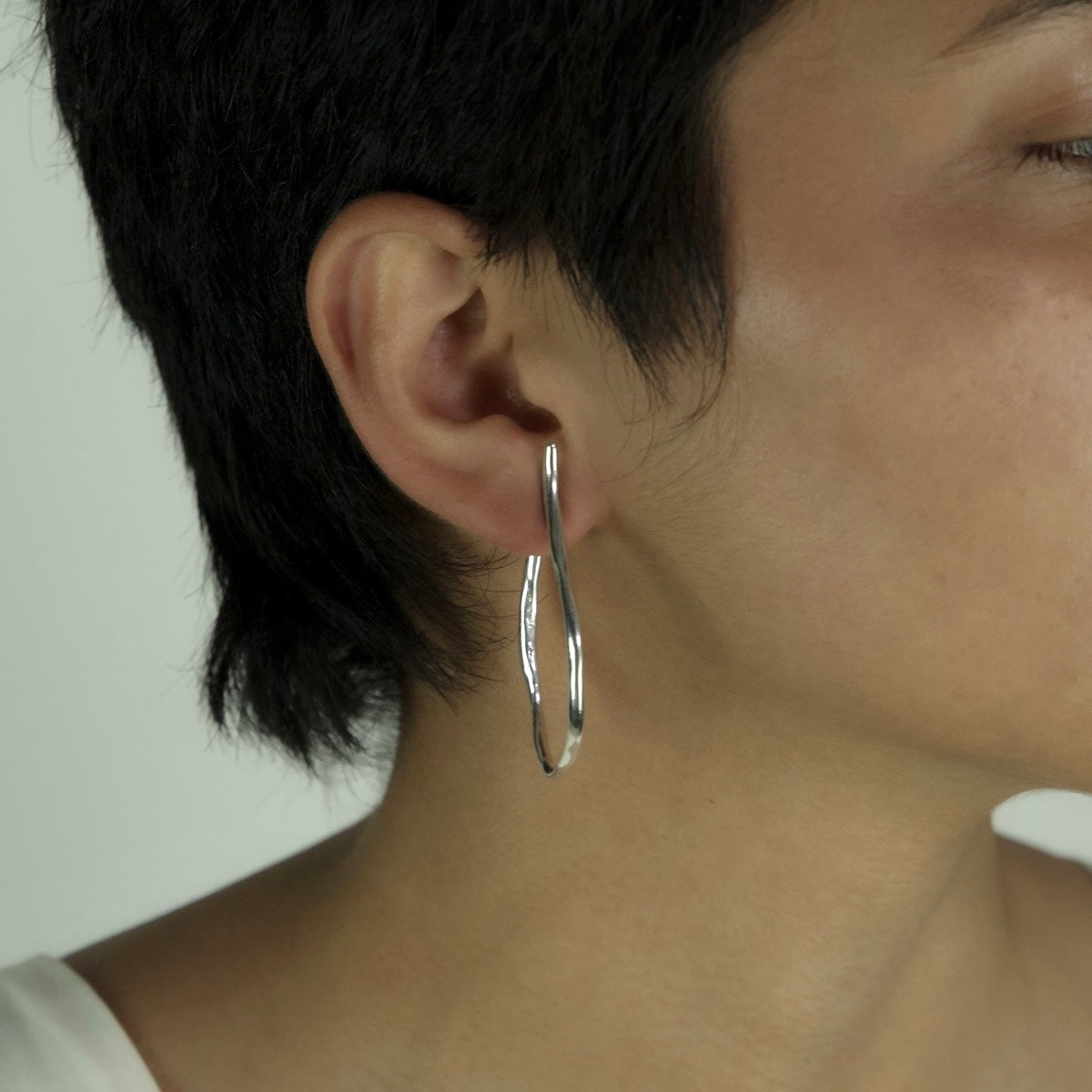 The Big Circle hoops are handcrafted from 925 sterling silver, presenting a crinkled form. They create a slightly wavy movement at the top. They are polished.