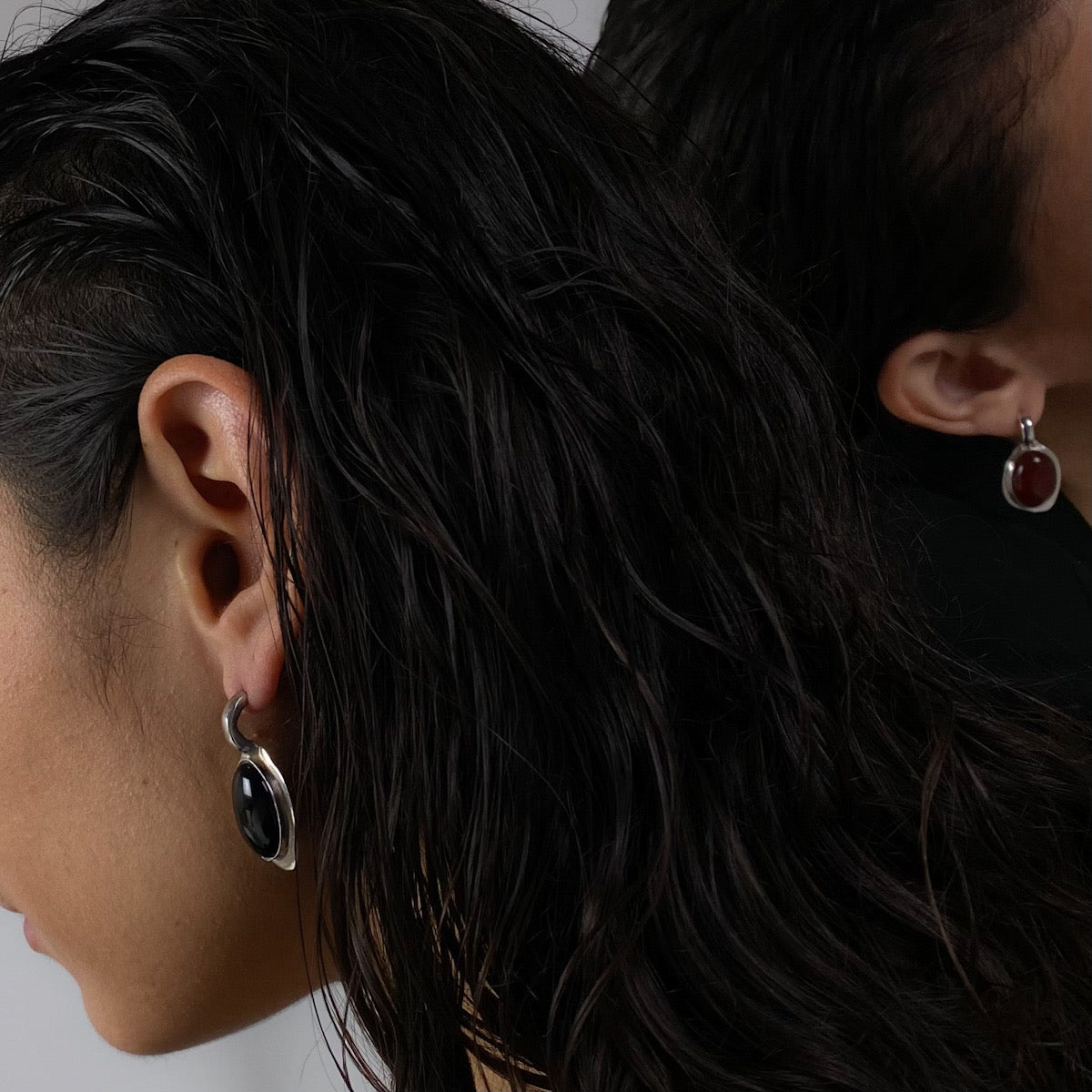 Galene earrings are handmade and made of 925 silver. They are smooth and shiny. The stone featured in the earrings is a semi-precious gemstone. There are two color options: red (carnelian) and black (agate).