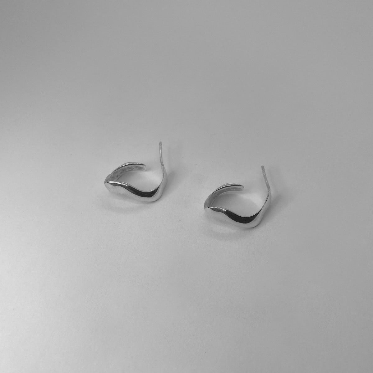 Handmade wavy oval-shaped hoops crafted from sterling silver 925