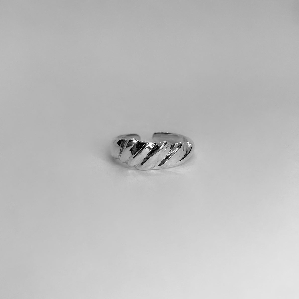The Parz ring is a handmade piece made of 925 sterling silver. It is thin and features diagonal lines, creating a sleek and glossy appearance