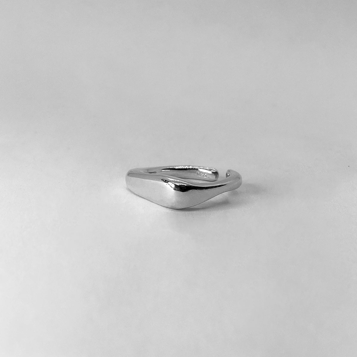 The Passion ring is a handcrafted piece made of 925 sterling silver. Its shape is square, with one edge thicker than the other. It is smooth and shiny