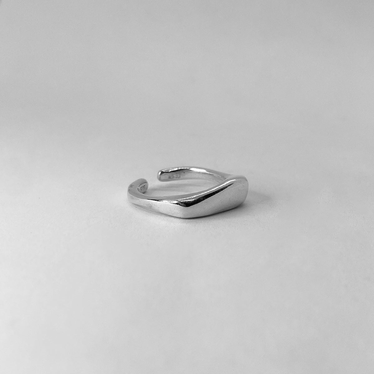 The Passion ring is a handcrafted piece made of 925 sterling silver. Its shape is square, with one edge thicker than the other. It is smooth and shiny