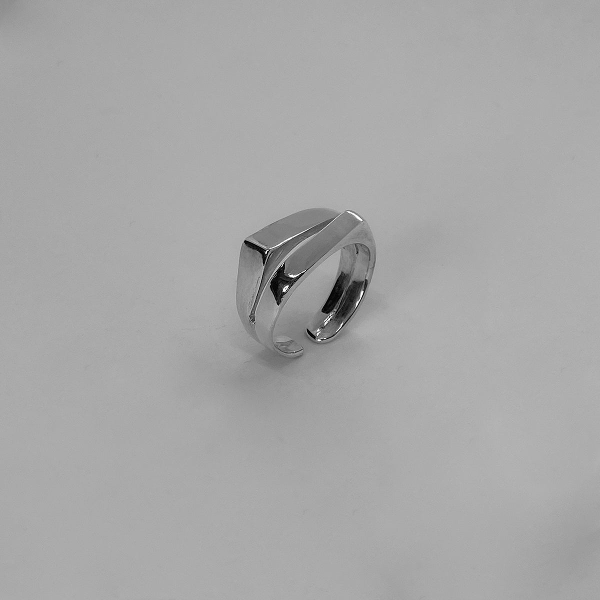 The Sevan ring is a handmade piece made of 925 sterling silver. It consists of two square bands of silver. It has a smooth and glossy finish