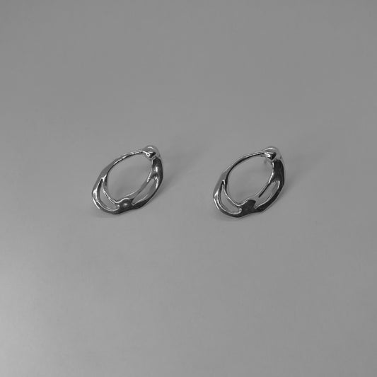Leim earrings are handmade from 925 sterling silver. Their shape is oval with various cuts on the inside, and they are polished and shiny