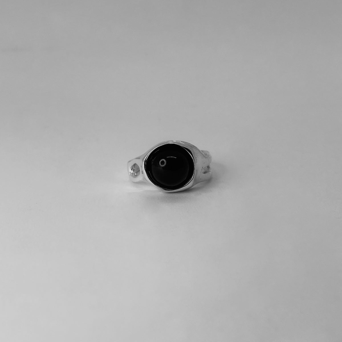 The Mineral ring is a handmade piece made of 925 sterling silver. It features a smooth and glossy surface, adorned with a semi-precious stone in three options: black agate, red carnelian, and brown tiger eye. Around the ring, there are openings, adding elements of elegance. The ring is open and adjustable, allowing for customization for up to three sizes. Therefore, it is important to know your ring size.