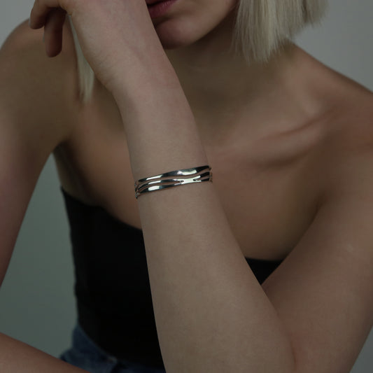 The Abrik bracelet is handmade from 925 sterling silver. It has several irregular stripes on the inside. It is smooth and shiny