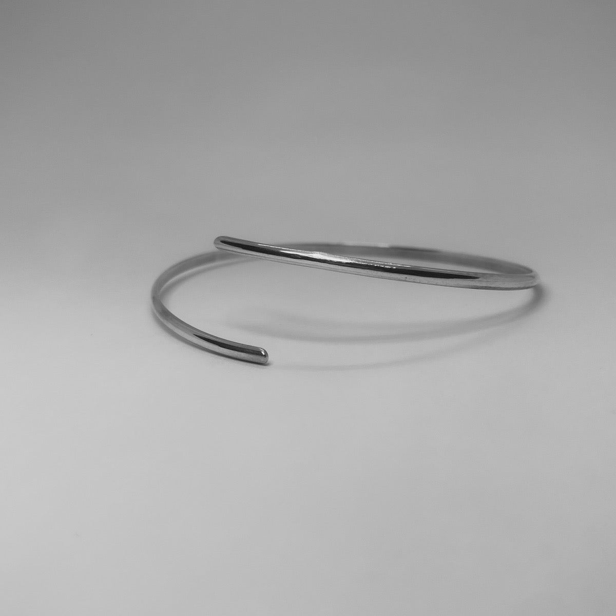 The Foot Bracelet is a handmade piece crafted from sterling silver 925. It features a slim silver band with elasticity, allowing it to be adjusted either lower or higher on the ankle. Additionally, it can be worn on the wrist. This minimal and elegant silver bracelet adds a touch of sophistication to your style.