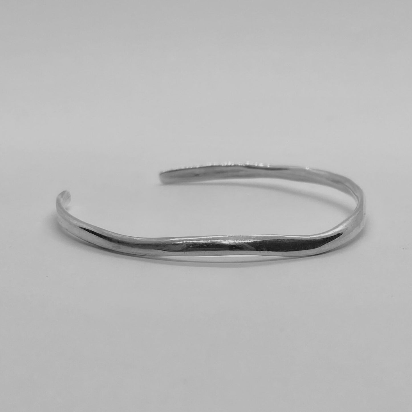 The Branch bracelet is a handmade creation crafted from sterling silver 925, featuring an exquisite and delicate minimal design. It gently fits low on the wrist, providing a smooth and glossy sensation.