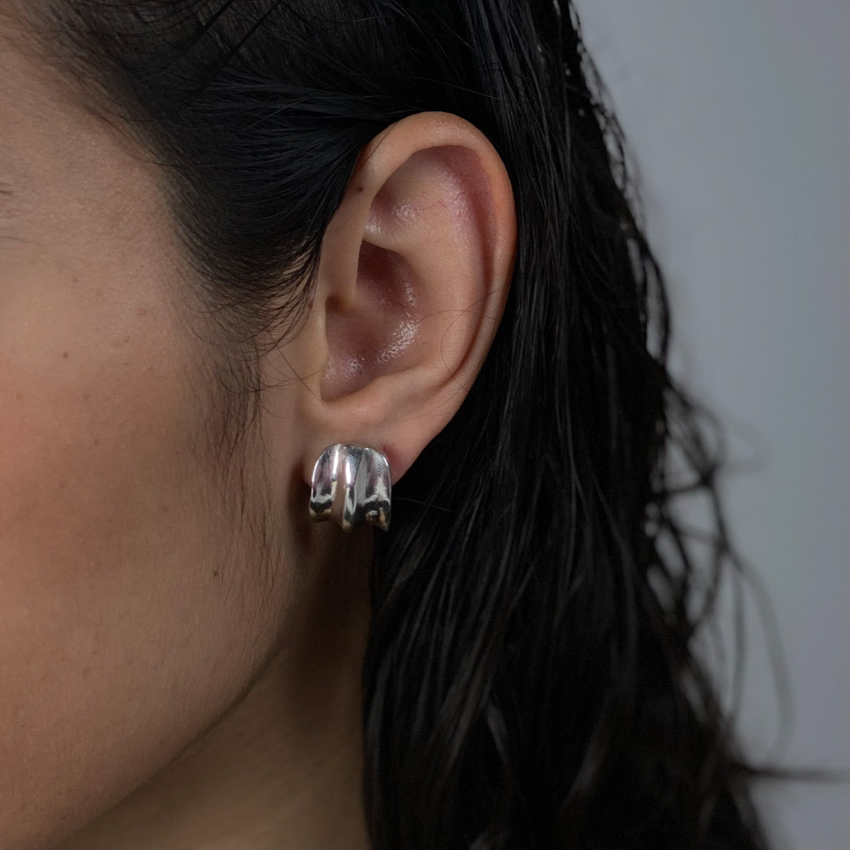 The Carved earrings are handmade, crafted from sterling silver 925. Their broad surface beautifully embraces the ear, providing a smooth and glossy finish. They are shipped within 2-10 business days.