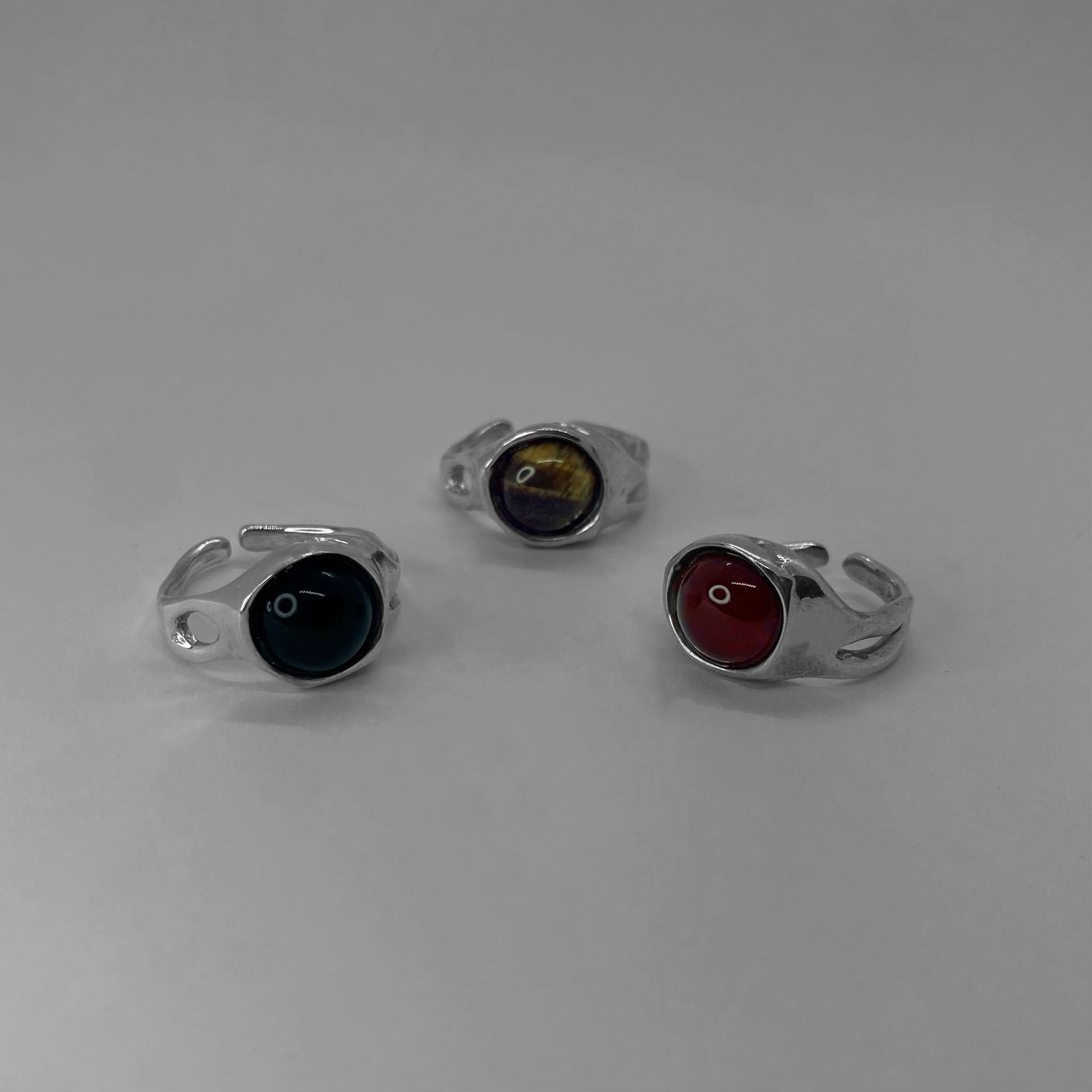 The Mineral ring is a handmade piece made of 925 sterling silver. It features a smooth and glossy surface, adorned with a semi-precious stone in three options: black agate, red carnelian, and brown tiger eye. Around the ring, there are openings, adding elements of elegance. The ring is open and adjustable, allowing for customization for up to three sizes. Therefore, it is important to know your ring size.
