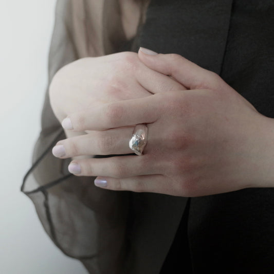 The Semilia ring is handmade and crafted from sterling silver 925. It boasts an irregular shape and volume, with a smooth and glossy finish. The adjustable feature at the back allows for resizing, covering up to 3 sizes.