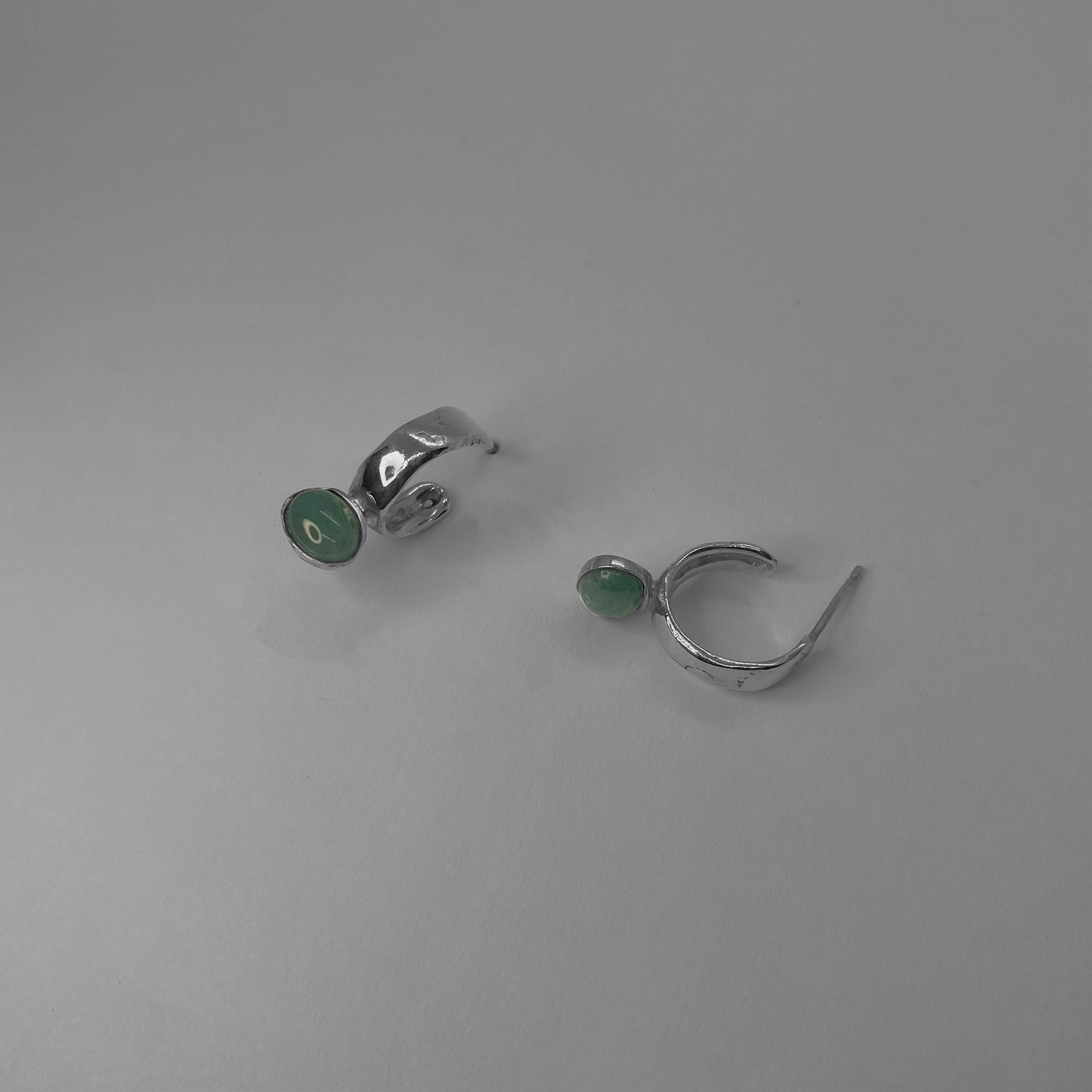 The small circle earrings are handmade and crafted from silver 925. The accompanying stone is semiprecious and is called green agate. The earrings are smooth and glossy.