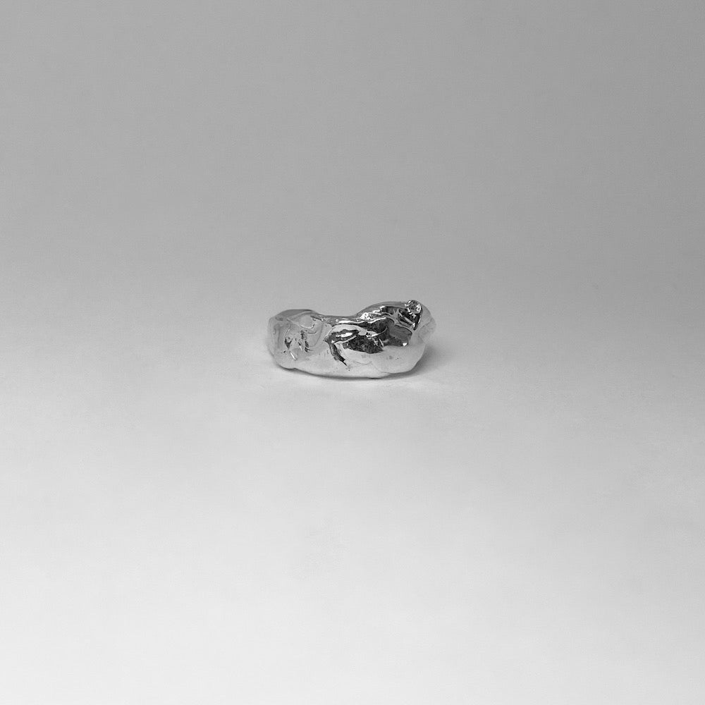 The Carmen ring is a handmade piece crafted from sterling silver 925. With its irregular shape and untreated texture, it exudes a unique aesthetic, while its glossy surface adds elegance. On the back, there's an adjustable feature accommodating up to 3 sizes, allowing you to wear it comfortably on any desired finger.
