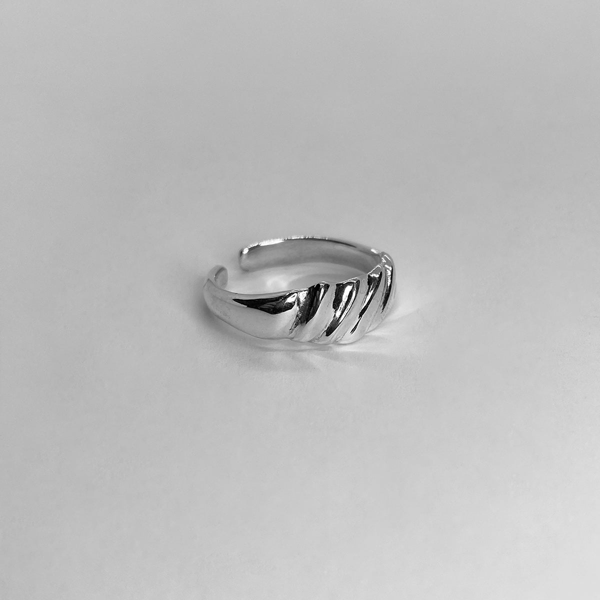 The Parz ring is a handmade piece made of 925 sterling silver. It is thin and features diagonal lines, creating a sleek and glossy appearance