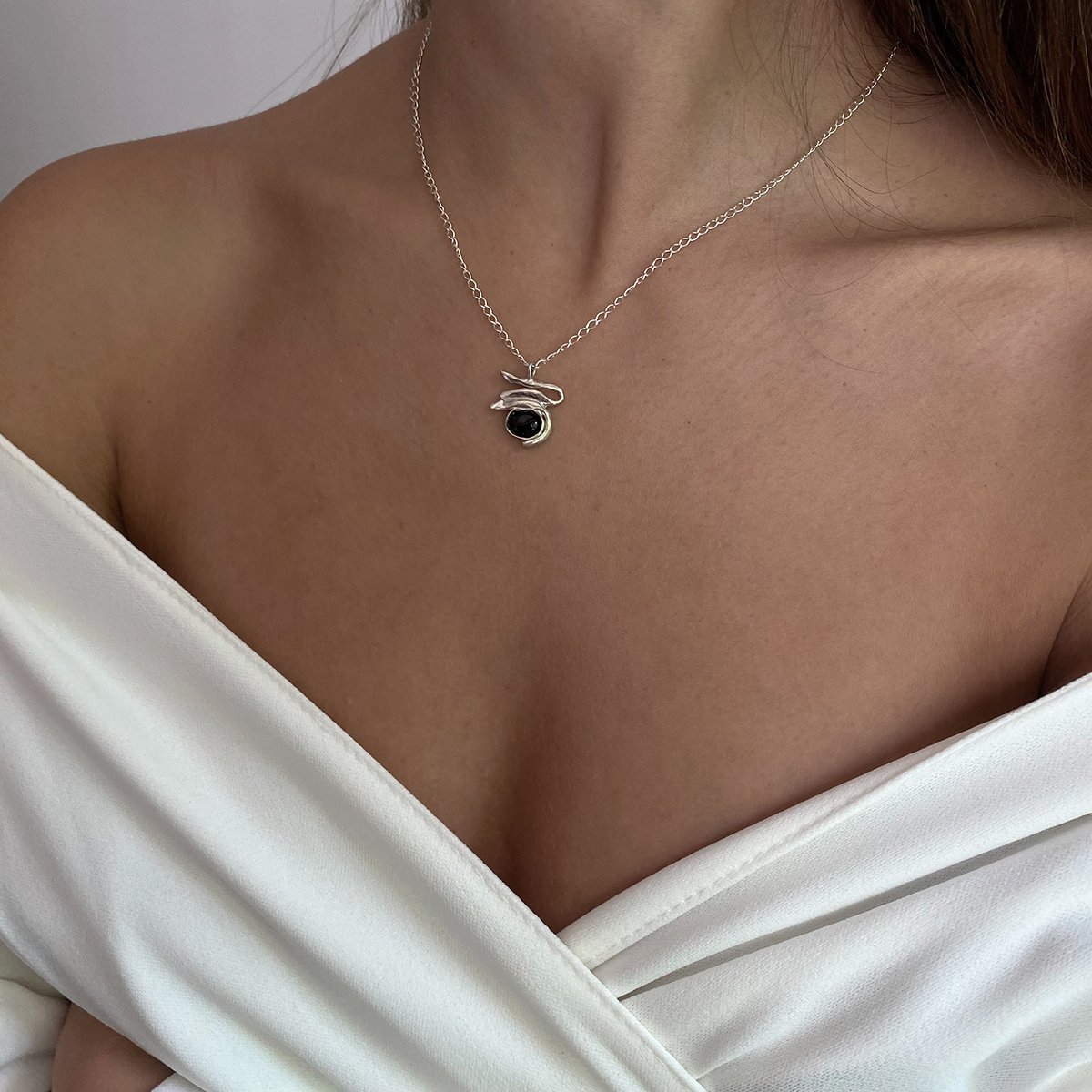The Gloriosa necklace is a handmade piece made of 925 silver. It has a smooth and polished surface and includes semi-precious stones in three different colors (white, green, black). The length of the chain in the photo is 40 cm.